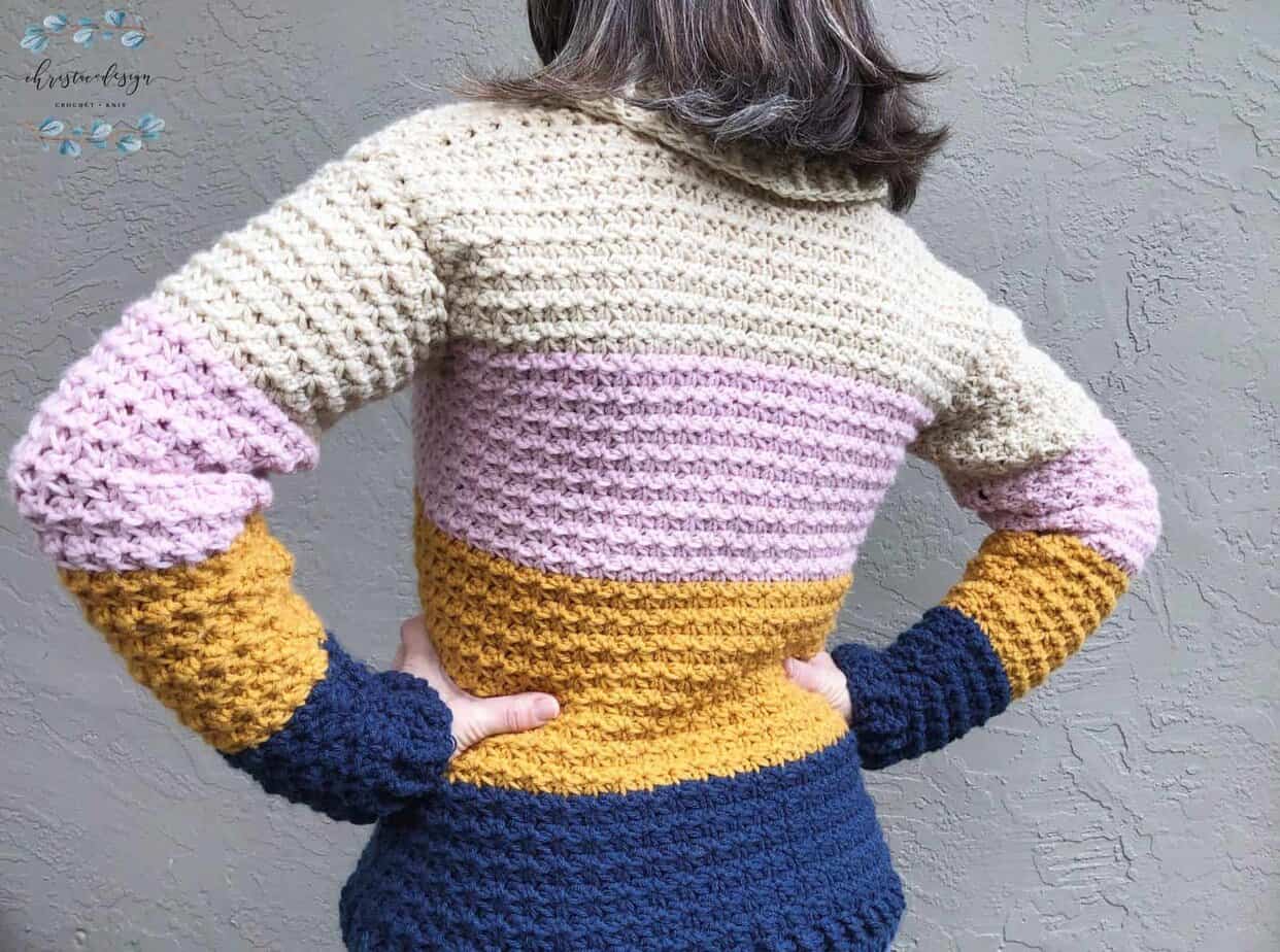 picture of back woman in crochet textured sweater blue gold pink beige stripes
