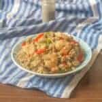 Delicious stir fried shrimp quinoa bowl on a blue cloth