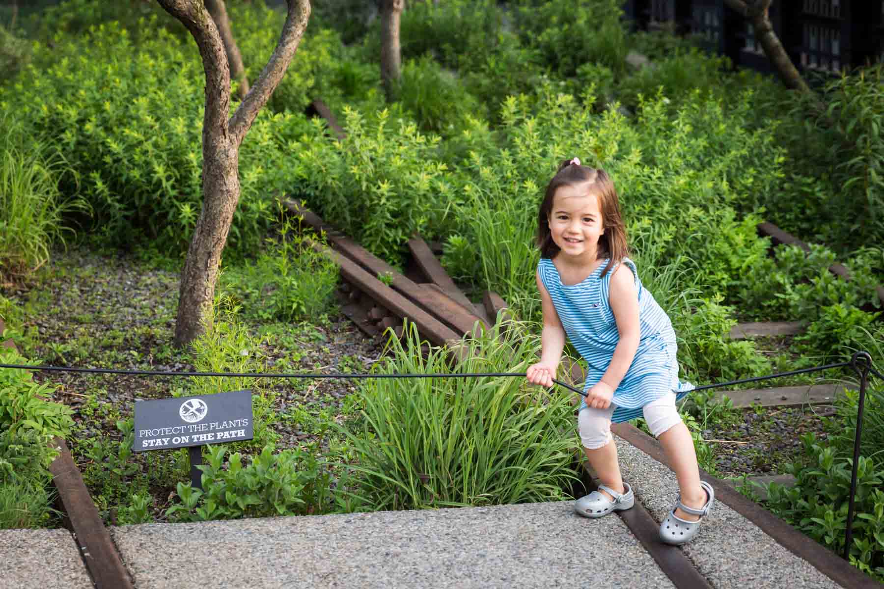 Little girl stepping over fence for an article on High Line family portrait tips
