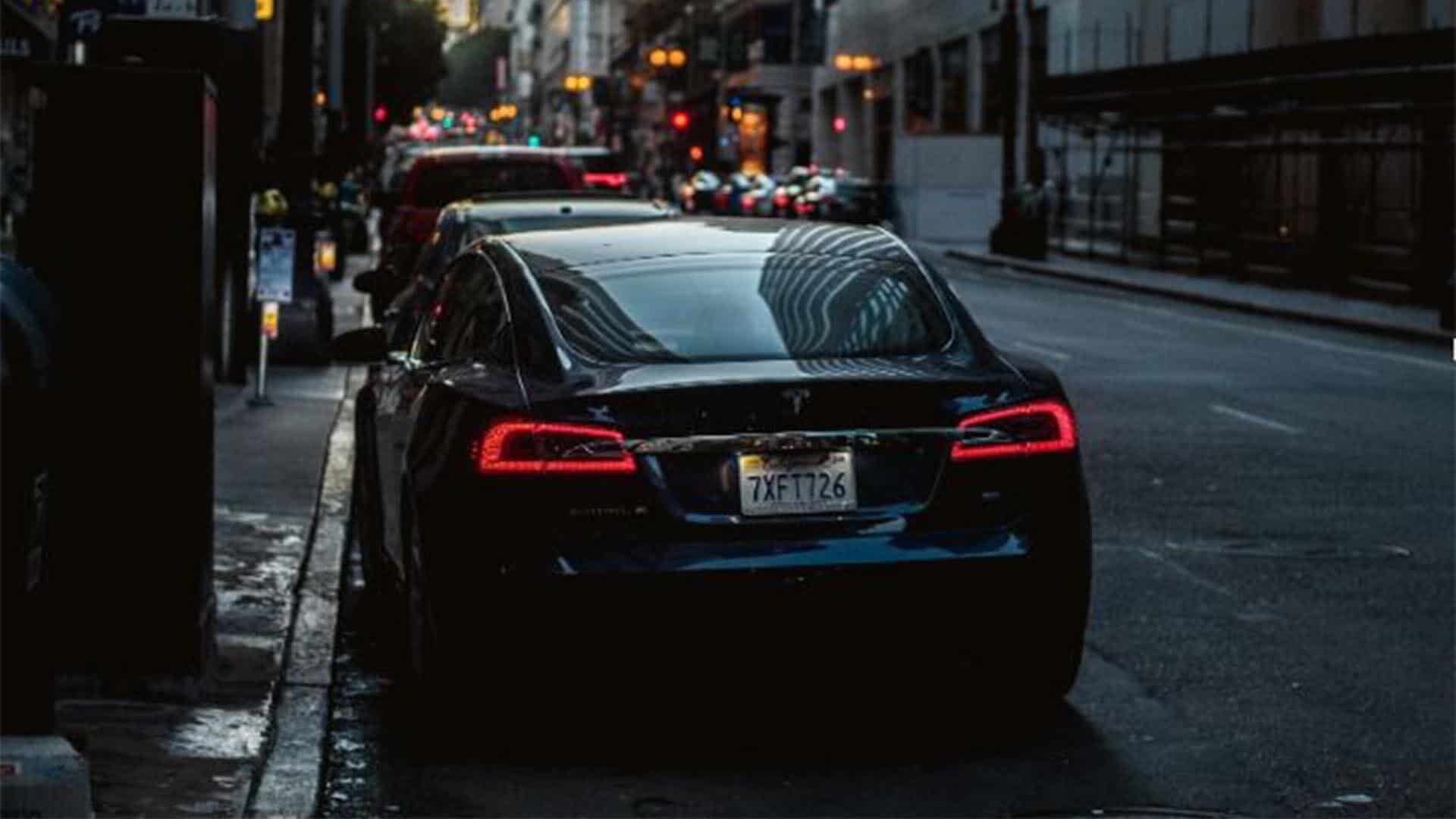black tesla sitting on street for uber vs lyft pricing post