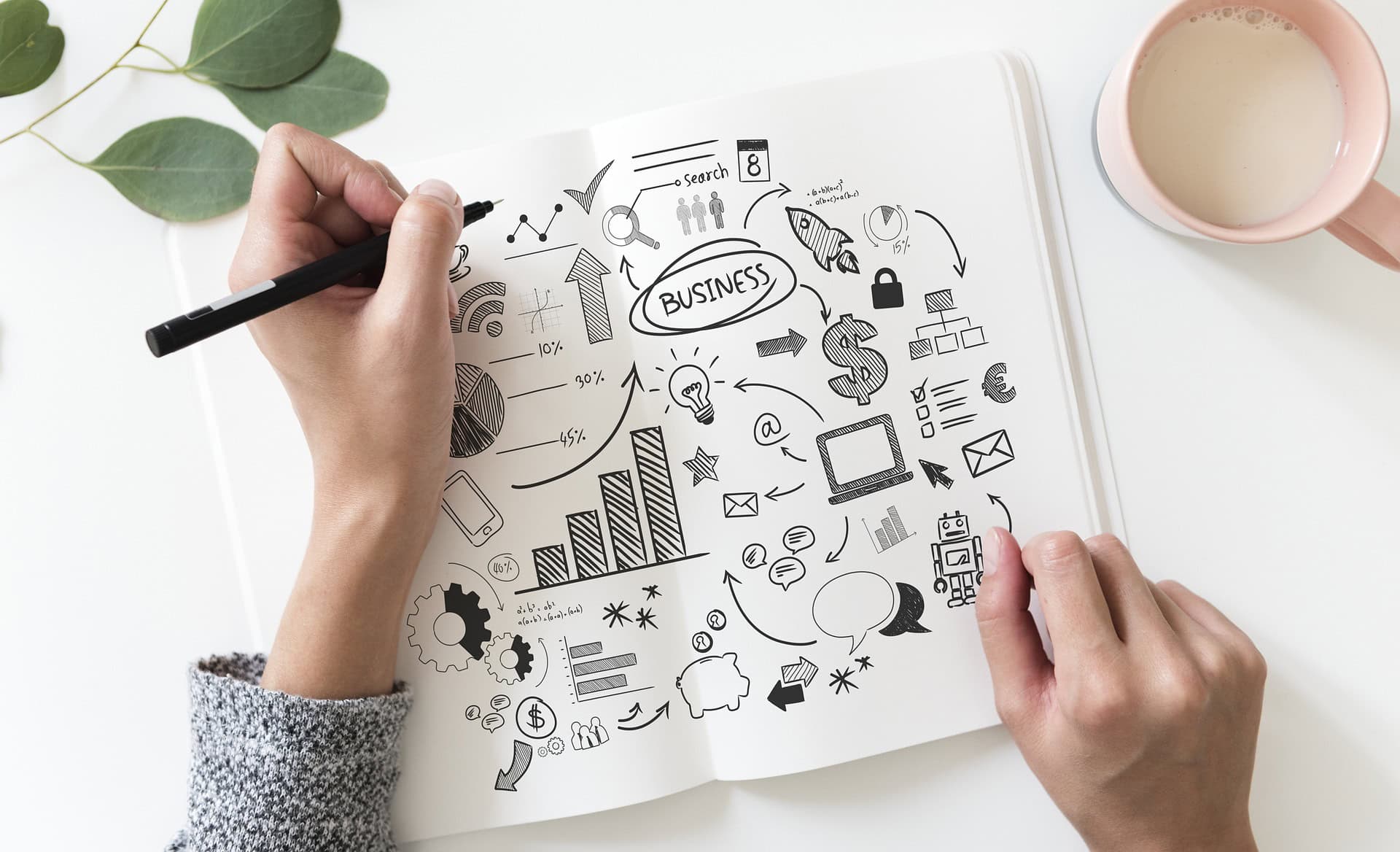 a woman doodling in a pad on business topics to come up with a design for a portfolio