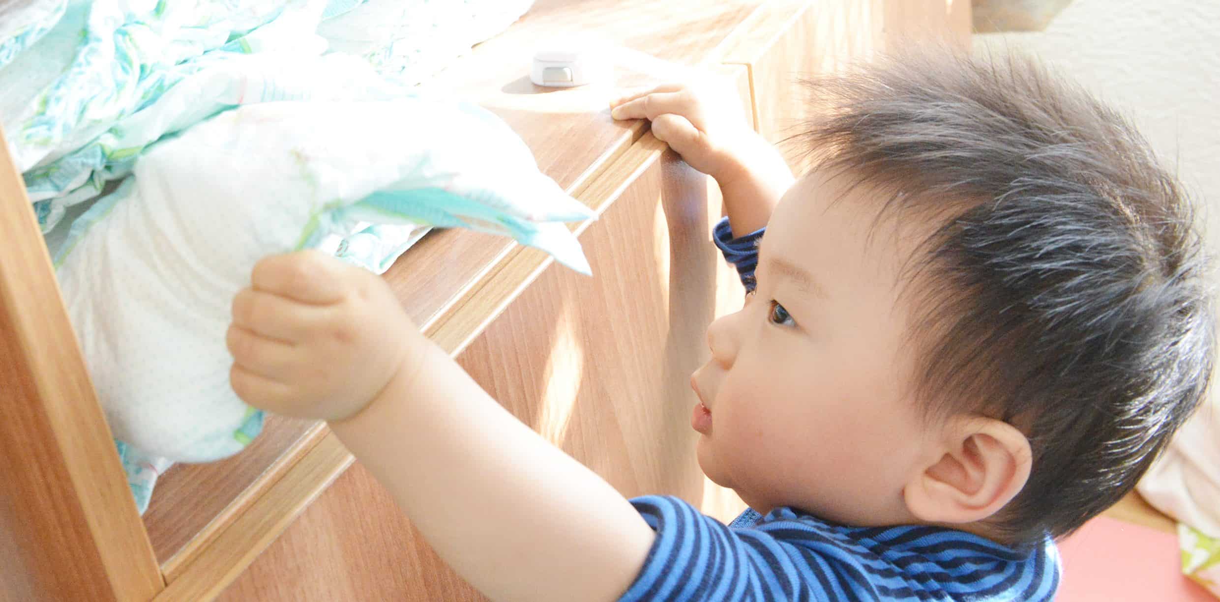 child reaching for nappies- potty training