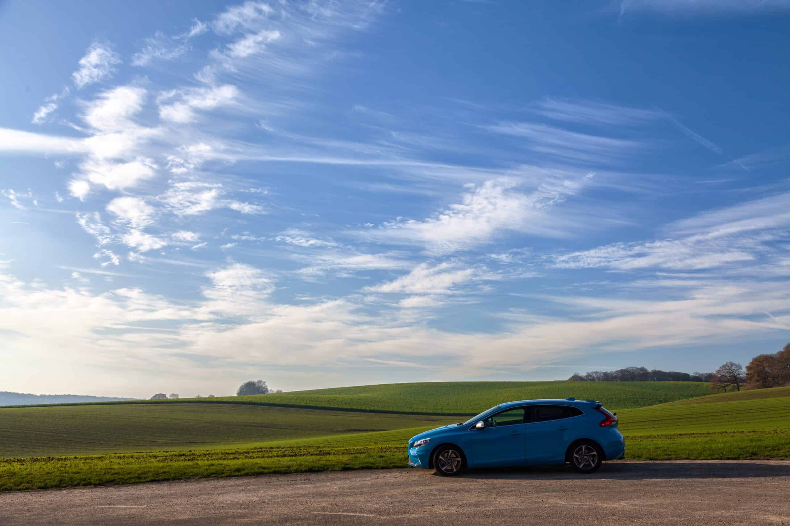 car on a road with a beautiful blue sky