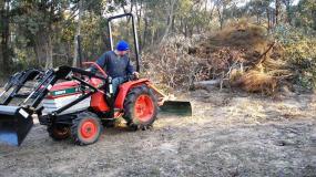 John Hughson operates his remanufactured Kubota tractor on his block.