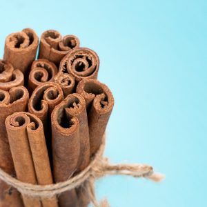 cinnamon sticks Ground cinnamon, cinnamon sticks, tied with jute rope on blue background with copy space