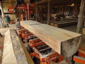 band saw with saw mill and large log in workshop setting
