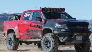 red chevy silverado with shocks in mud background