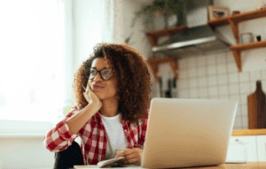 reference letter image: woman staring thoughtfully into space infront of her laptop