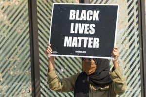 Woman holding a sign that says "Black Lives Matter"