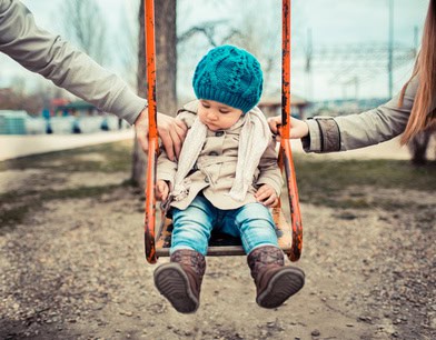 Divorce and Separation Child Custody Issues Sad child on a swing between her divorced parents