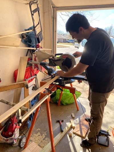 man cutting board with saw