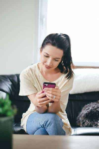 calgary-graphic-web-designer-best Brunette girl smiling looking at phone