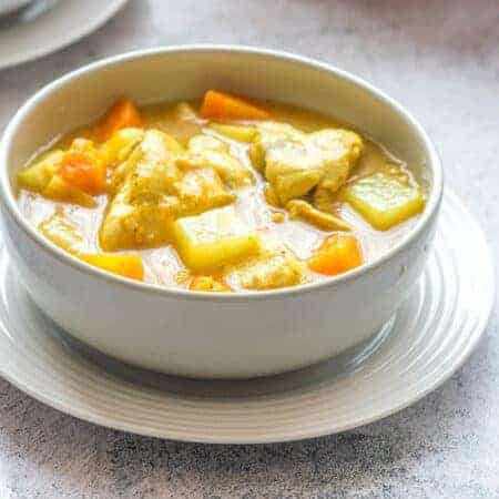 Chicken soup with veggies and dumpling in a white bowl