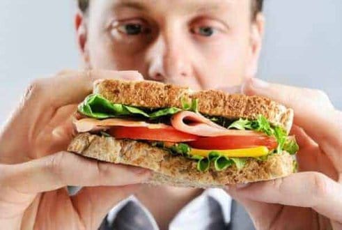 homem come um sanduíche