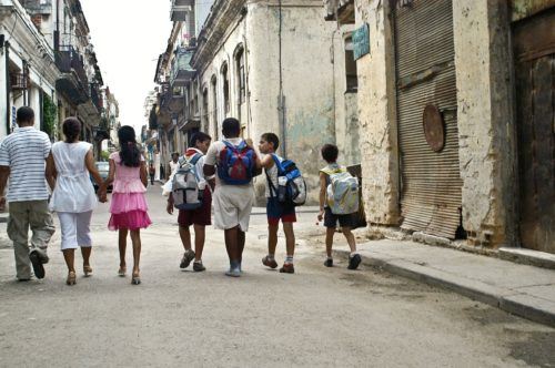 Kids, teens and parents explore a cuba city street.