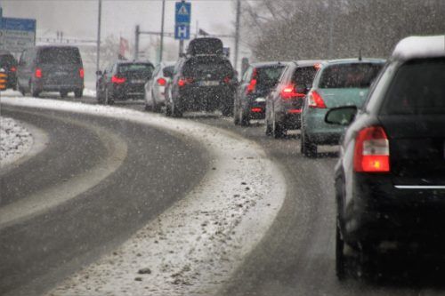 A long line of cars driving in snow.