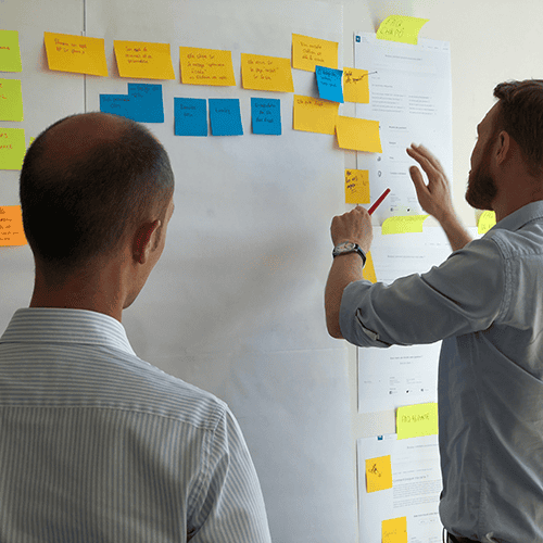 Men planning a video production project on a whiteboard