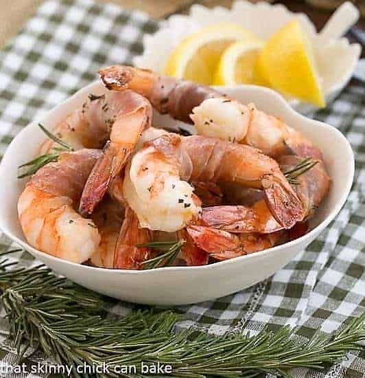 Rosemary Prosciutto Shrimp: Succulent, jumbo shrimp wrapped in prosciutto and flavored with rosemary and Sambuca! Rosemary Prosciutto Shrimp in a white bowl