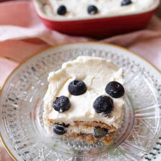 slice of icebox cake with blueberries on glass plate