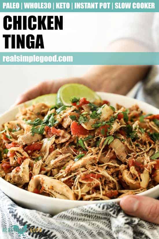 Angled vertical image of holding a bowl of shredded chicken with fresh cilantro and lime wedges. Text overlay at top for Pinterest.
