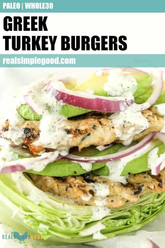 Close up image of Greek turkey burgers on top of lettuce with tzatziki sauce dripping down the sides. Toppings include avocado and red onion. Text overlay at top of image for pinterest.