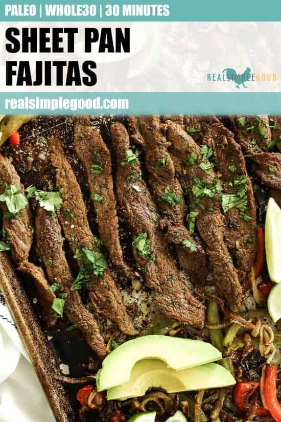 Close up vertical overhead shot with text overlay at top. Sheet pan fajitas on sheet pan with steak, red and green bell peppers and onion. Topped with fresh cilantro, sliced avocado and lime wedges.