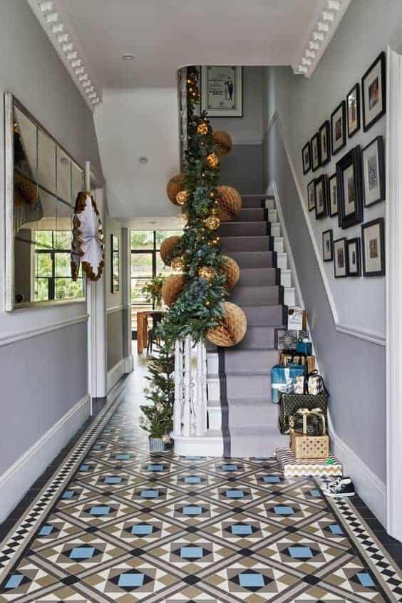 white, black, and blue mosaic flooring tiles in geometrical arrangement for entrance hallway with white and grey staircase