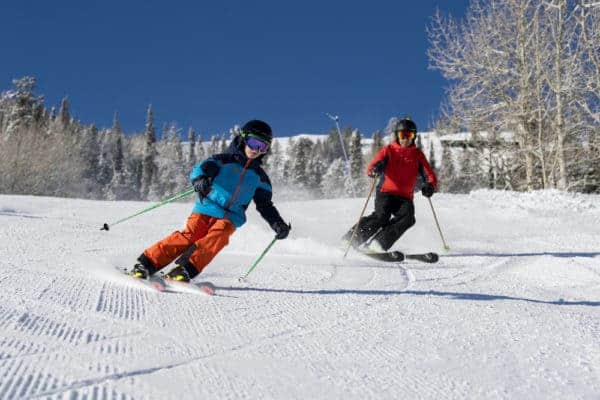 A father and a son skiing the wide beginner trails in park city, utah