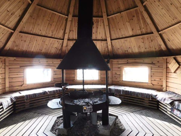 A typical finnish picnic hut with benches and a fire.