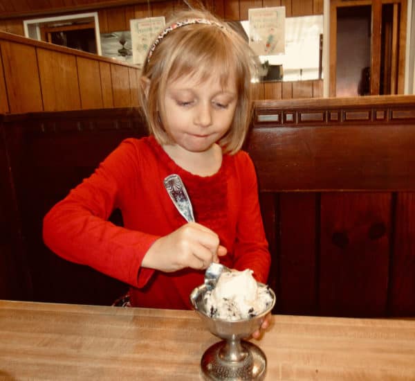 A girl eats housemade chocolate chip ice cream at sip 'n' soda in southampton, long island.
