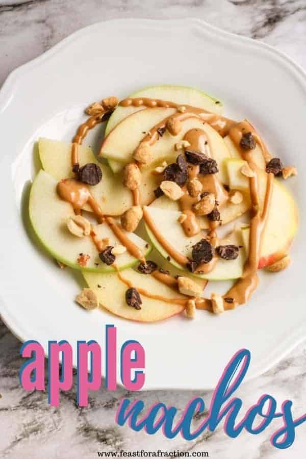 sliced apples with peanut butter and chocolate on white plate with title text "apple nachos"
