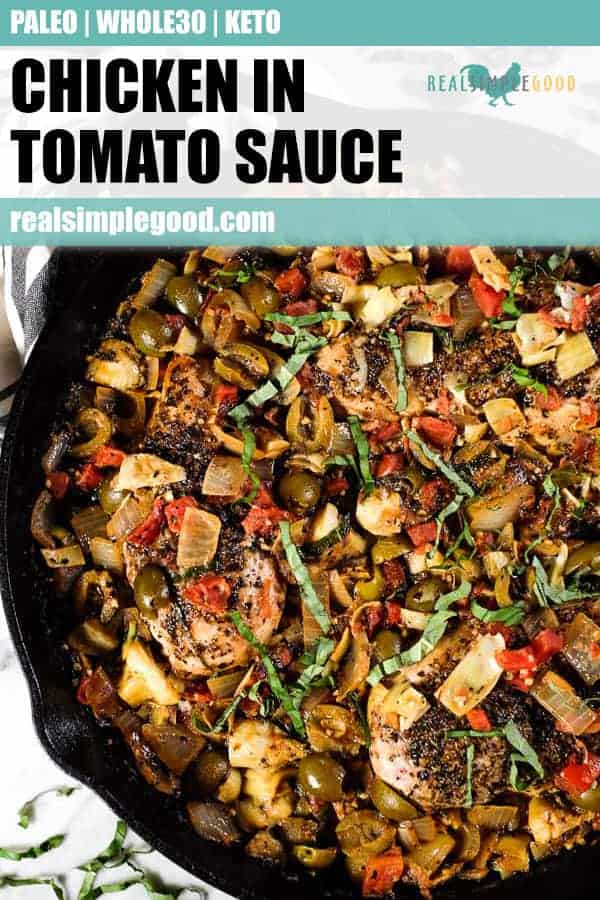 Chicken in tomato sauce in a large skillet with fresh basil on top.