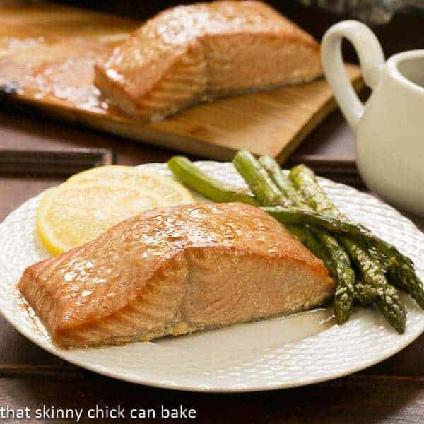 Grilled Cedar Plank Salmon - an easy, elegant recipe for grilling salmon Grilled Cedar Plank Salmon on a dinner plate with more salmon on a plank in the background