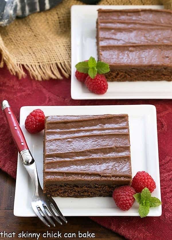 Chocolate Sheet Cake | A scrumptious dessert for a crowd Chocolate Sheet Cake slices on a square white plates with raspberries
