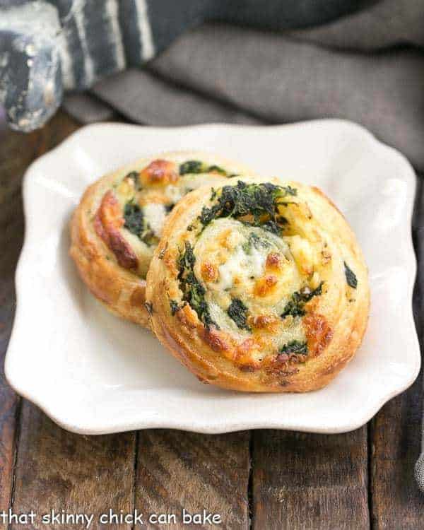 Spinach Feta Pinwheels -The marvelous flavors of Greek spanakopita without all the work! Spinach Feta Pinwheels on a white square plate