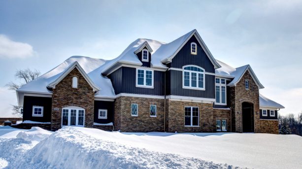 a craftsman house with half mixed brick and half navy blue siding