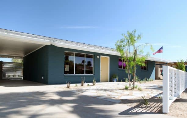 a modern ranch house with greenish-blue brick walls