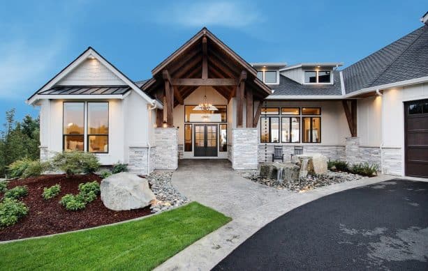 a modern farmhouse exterior with Drift of Mist SE 9166 paint color and stained wood accents