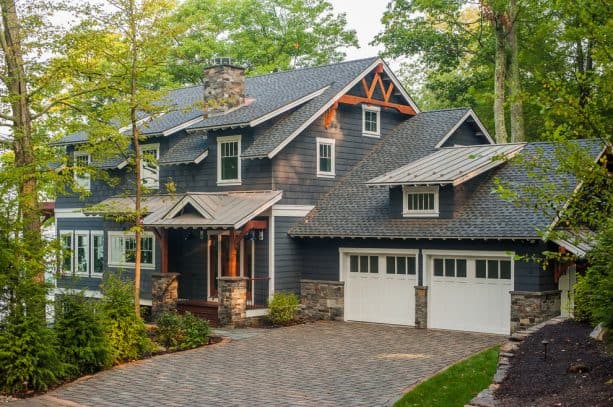 a rustic house with dark grey siding and white exterior trim
