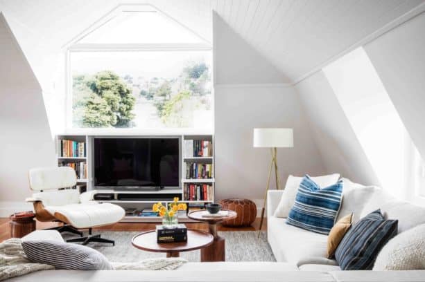 a TV placed inside a custom white entertainment center with bookshelf feature