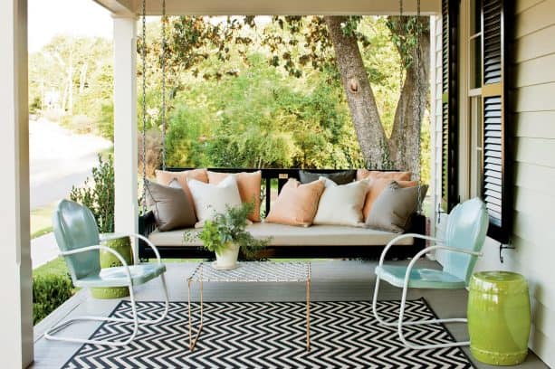 a warm white house with black shutters and black swing