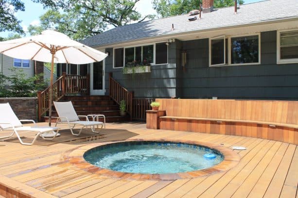 a traditional exterior with dark grey shingle siding and custom cedar deck