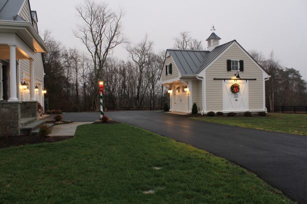 a detached carriage house located in front of a farmhouse building