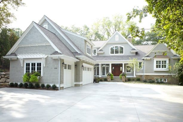 a separated two-story garage in front of a traditional residence