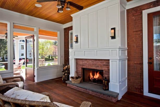 a timeless-looking screened porch fireplace with wainscoting