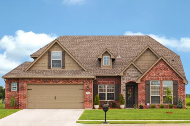 creating a cozy exterior with the combo of taupe siding and red brick wall