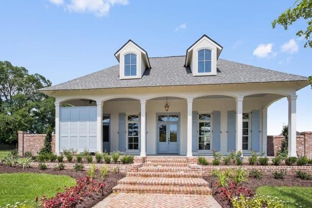 a white brick house with matching grey trim and shutters