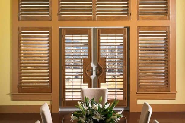 plantation shutters from medium hardwood material on white French doors