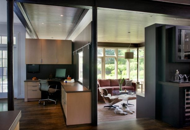 a glassless window with black sliding closures as a part of a partition in a contemporary interior