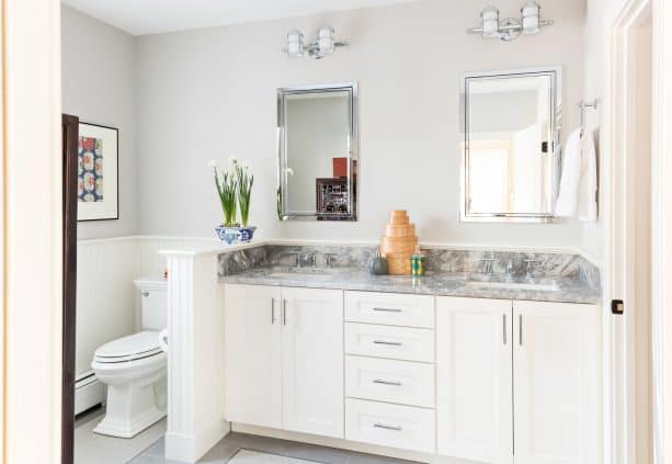 a half wall covering the toilet area in a traditional bathroom